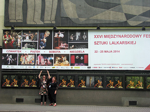 Ananda & Charlotte wijzen naar de afbeelding van Transit op de enorme gevel van Theater Banialuka